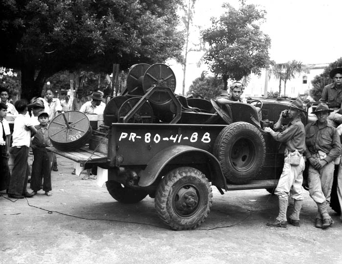 Corporal Serra of the 65th Infantry talks over a telephone line which has just been laid by the Army in Caguas, Puerto Rico. November 1941.  SC 126168